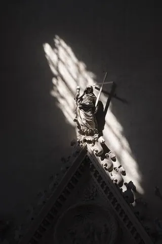 Shafts of light hit statue in the Basilica di San Petronio, Bologna